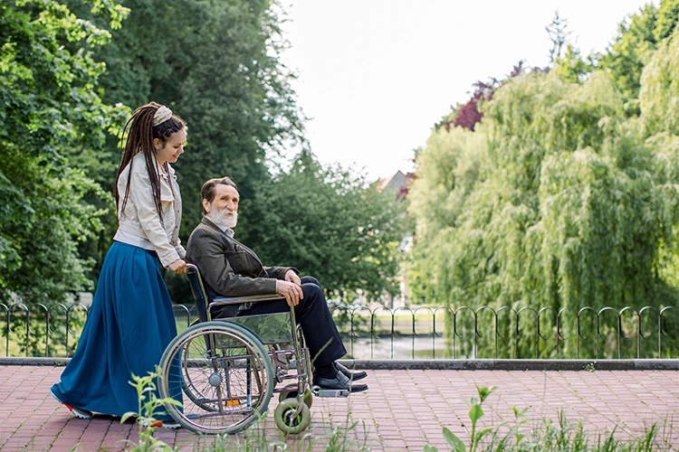 Hippie girl pushing man wheelchair